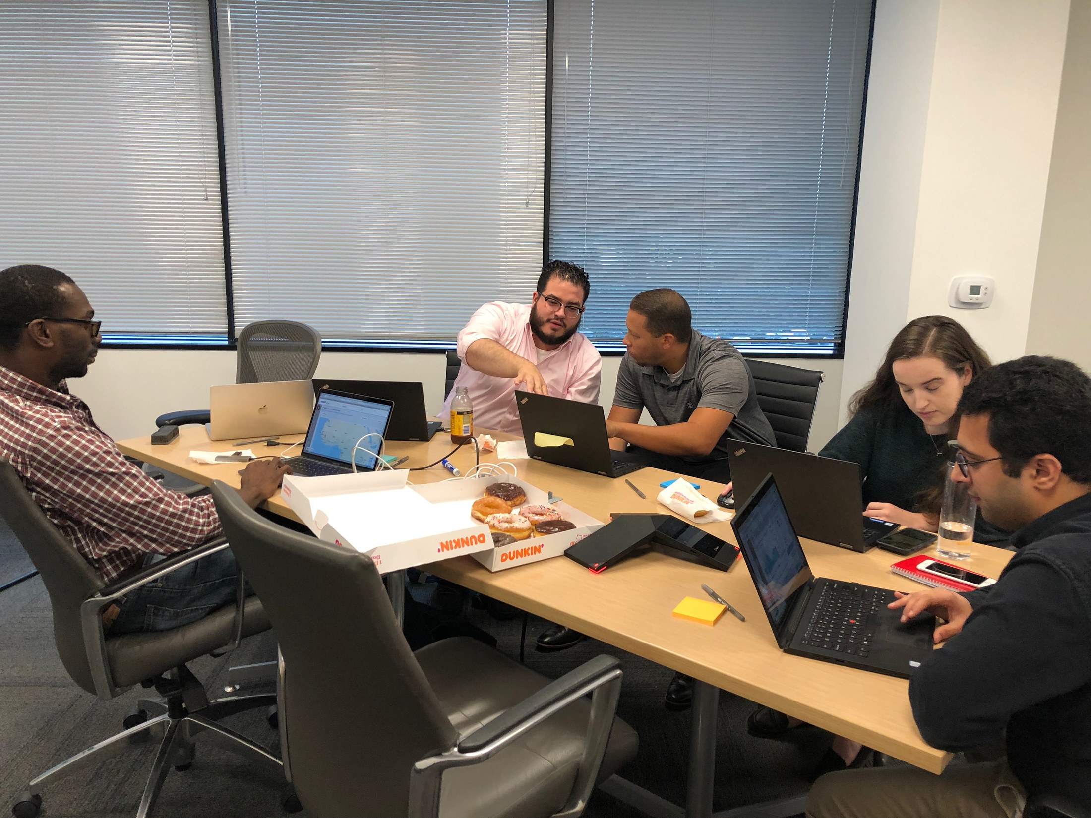 Team working together around a table with laptops